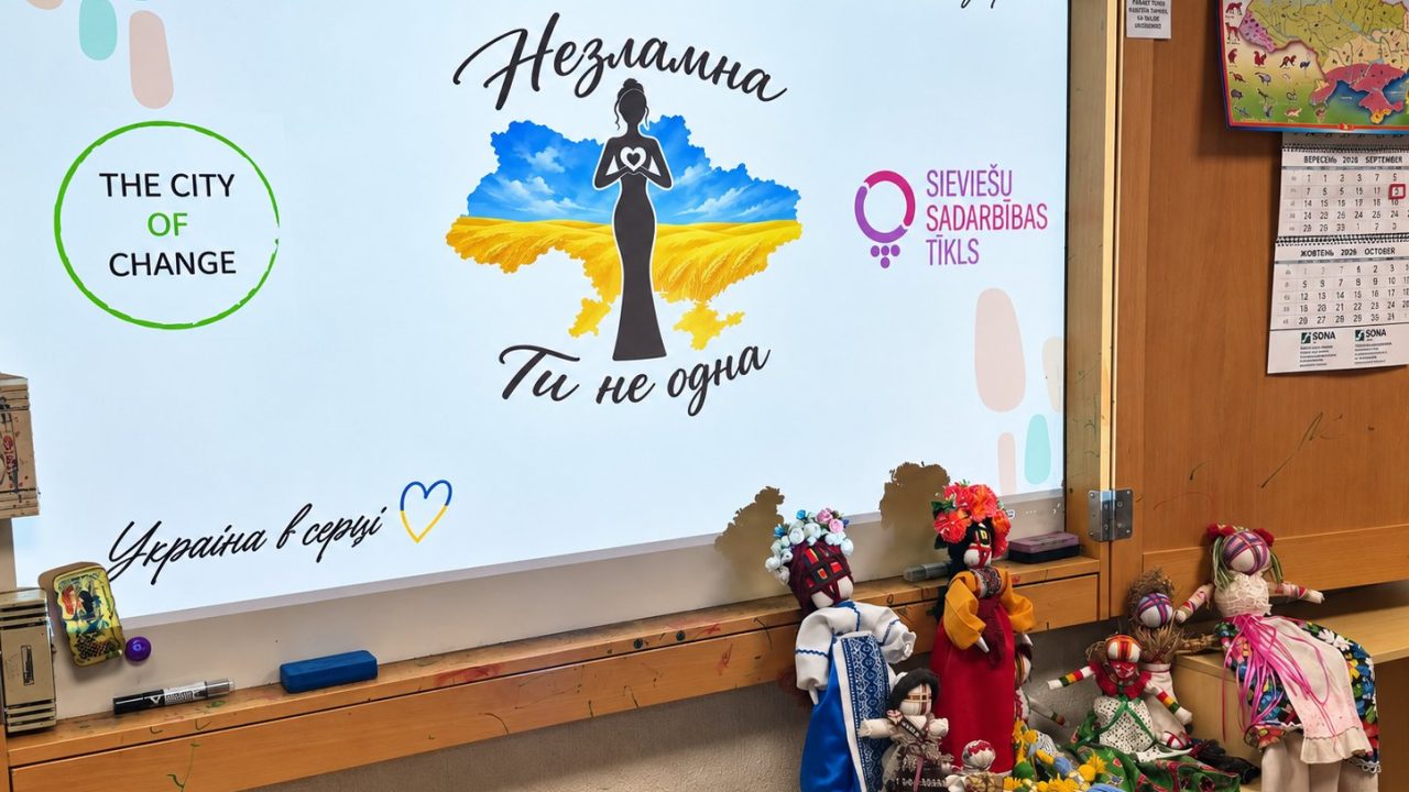Екран із написом «Незламна. Ти не одна» та зроблені на майстер-класі ляльки-мотанки в різнокольорових строях