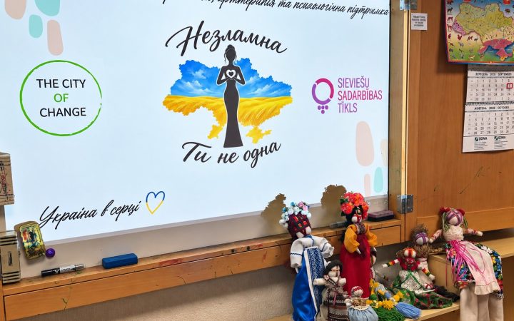 Екран із написом «Незламна. Ти не одна» та зроблені на майстер-класі ляльки-мотанки в різнокольорових строях